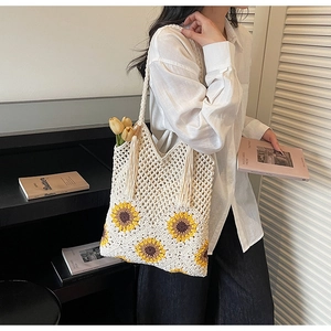 Close-up of bohemian crochet tote bag with sunflower pattern and fringe tassels