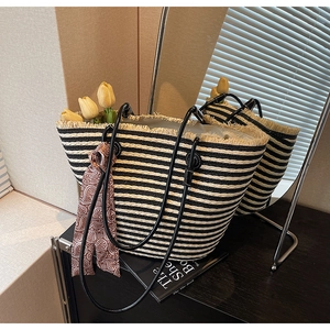 Detail of striped woven tote bag with beige fringe and brown paisley scarf ornament