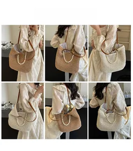 Detail of woven straw tote bag featuring elegant pearl handles and brown leather strap