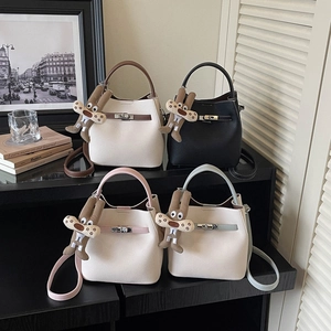Elegant pebbled leather bucket handbag with metal lock and cute plush charm