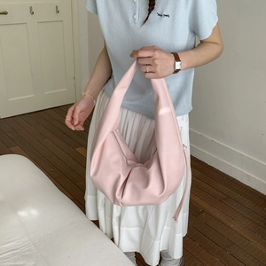 Detailed macro view of soft pink hobo bag with pleated texture and silver zipper finish