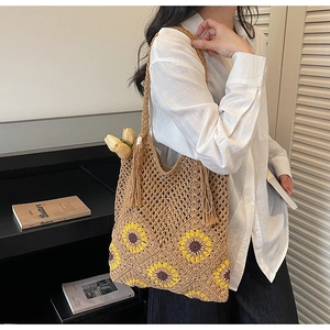 Detailed shot of handmade crochet shoulder bag with yellow sunflower embroidery and tassel