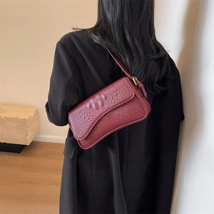 Dettaglio borsa a spalla in pelle bordeaux stampa coccodrillo con tracolla regolabile