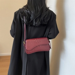 Dettaglio borsa a spalla bordeaux motivo coccodrillo con fibbia metallica vintage