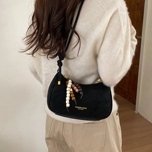 Detail of black crescent shoulder bag with vintage beaded zipper charms and gold logo