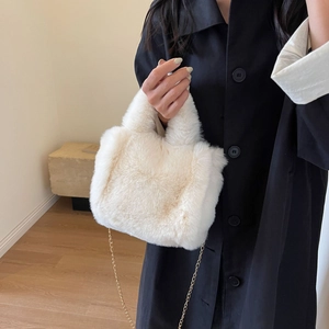 Détail du sac seau en fausse fourrure crème avec bandoulière chaîne dorée pour l'hiver