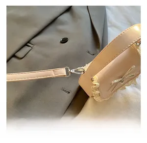 Detail of pink sweet mini bag with silver metal hook and removable shoulder strap