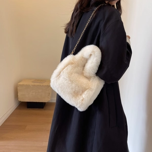 Texture détaillée du sac seau en peluche blanc avec une élégante chaîne dorée