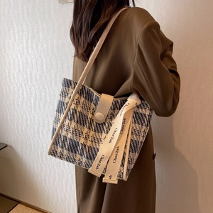 Detailed texture of blue and white tweed fabric on a stylish commute tote bag