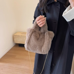 Gros plan du sac seau en peluche marron montrant la fourrure synthétique et la chaîne
