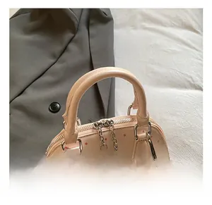 Close-up of pink polka dot shell bag showing comfortable handles and apple plush charm