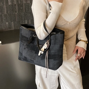 Close-up of contrast-colored tote bag with textured fabric and white animal charm