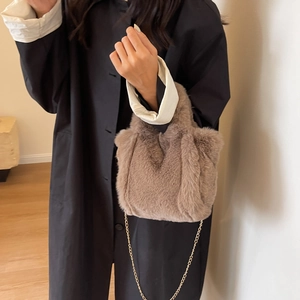 Détail du sac seau en peluche marron avec une chaîne en métal doré haut de gamme