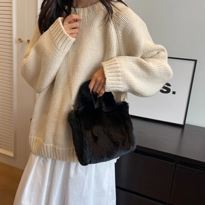 Détail du sac seau en fausse fourrure noire avec chaîne dorée pour l'hiver