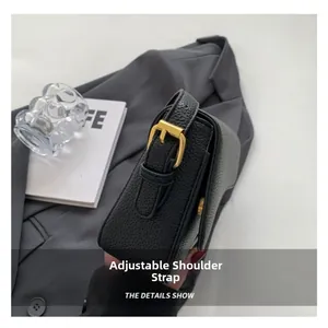 Dettaglio della borsa in pelle martellata nera con tracolla regolabile e fibbia in metallo dorato