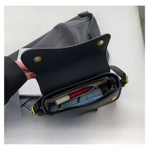 Vista interna della borsa in pelle nera con scomparto principale e tasca con zip