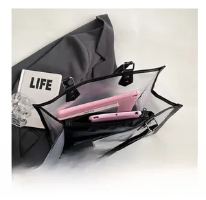 Detailed top view of large transparent PVC tote bag showing black handles and inner compartments