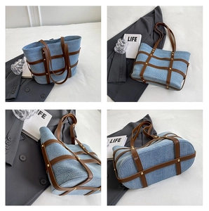 Detailed close-up showing denim tote bag texture, leather straps and golden rivet accents