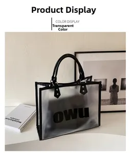 Close-up of transparent PVC tote bag featuring black OWU lettering and metal rivets