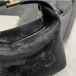 Detailed macro view of the vintage black PU leather texture with gold metal zipper accents