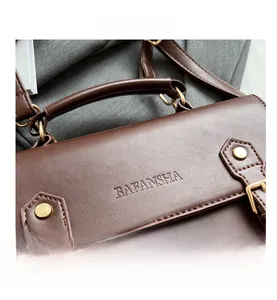 Detail of vintage brown leather satchel with brand embossing and precise stitching