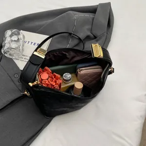 Interior view of black leather crossbody bag showing spacious storage for essentials