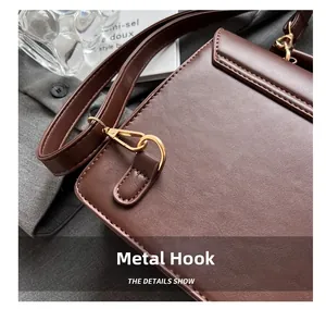 Detail of premium golden metal swivel hook on brown vintage leather shoulder bag