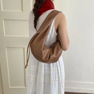 Brown leather minimalist hobo shoulder bag styled with a white dress for daily commute