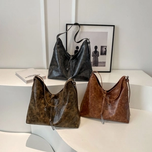 Detail view of large vintage tote bags in grey, olive green, and tan textured leather