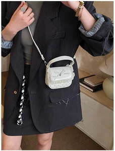 Close-up of a white mini handbag featuring delicate lace edges and a sweet ribbon bow