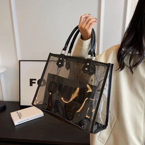 Detail of transparent PVC tote bag with black leather straps and printed inner pouch