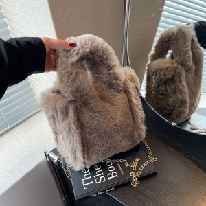 Détail du sac seau en peluche avec bandoulière chaîne dorée et poignée intégrée douce