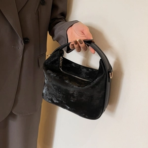 Detailed close-up of a black textured PU leather handbag with elegant gold metal hardware