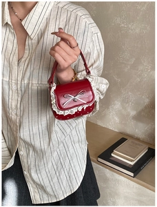 Detailed shot of red mini square handbag with white polka dots and lace trim accents
