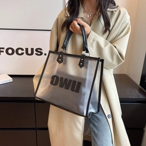 Detail of translucent frosted PVC tote bag with black leather straps and inner pouch