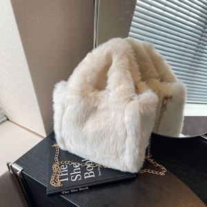 Gros plan du sac fourre-tout en fausse fourrure crème avec chaîne dorée élégante