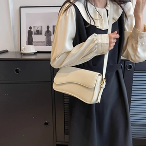 Dettaglio borsa beige a tracolla con grana litchi e patta a onda dorata