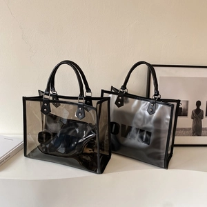 Detail view of large clear PVC tote bag set with inner pouch and sturdy black handles