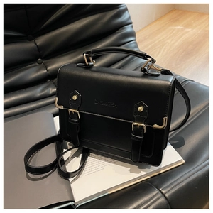 Detailed view of black PU leather vintage satchel with metallic buckle fasteners and handle