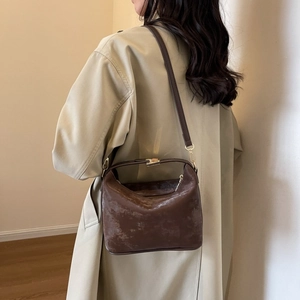 Detailed texture of dark brown PU leather crossbody bag with vintage crackle finish