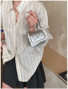 Detail of silver metallic mini bag featuring white lace trim and pink heart polka dots