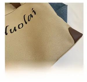 Detailed macro view of khaki canvas fabric texture and brown leather corner reinforcement