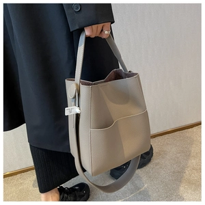 Vue détaillée du sac seau en cuir taupe avec large bandoulière et poche latérale