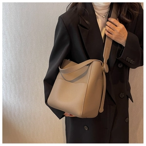 Sac seau en cuir grainé gris éléphant porté avec une large bandoulière confortable