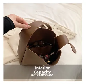 Detail of the large brown leather bucket bag interior with cosmetics and zip pocket