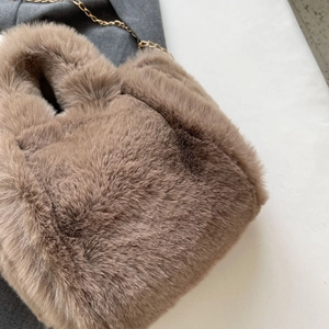 Détail latéral d'un sac seau en fausse fourrure marron avec chaîne dorée chic