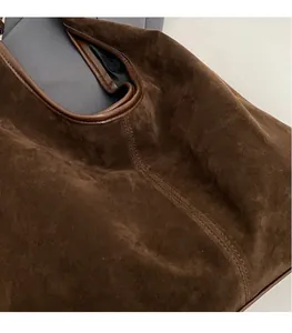 Detailed macro view of high-quality brown suede fabric with precise stitching craftsmanship