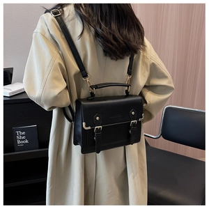 Classic black matte vintage backpack with dual buckles shown on model in street style