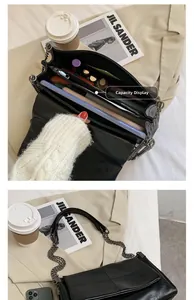 Vue intérieure d'un sac à chaîne en cuir noir brillant montrant sa grande capacité de rangement