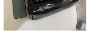 Gros plan d'un sac en cuir noir montrant la texture fine et les coutures de qualité